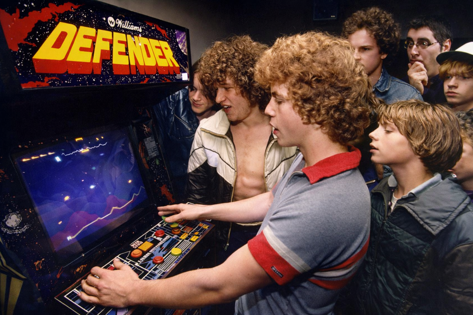 Jugadores de Defender en un salón arcade de los 80