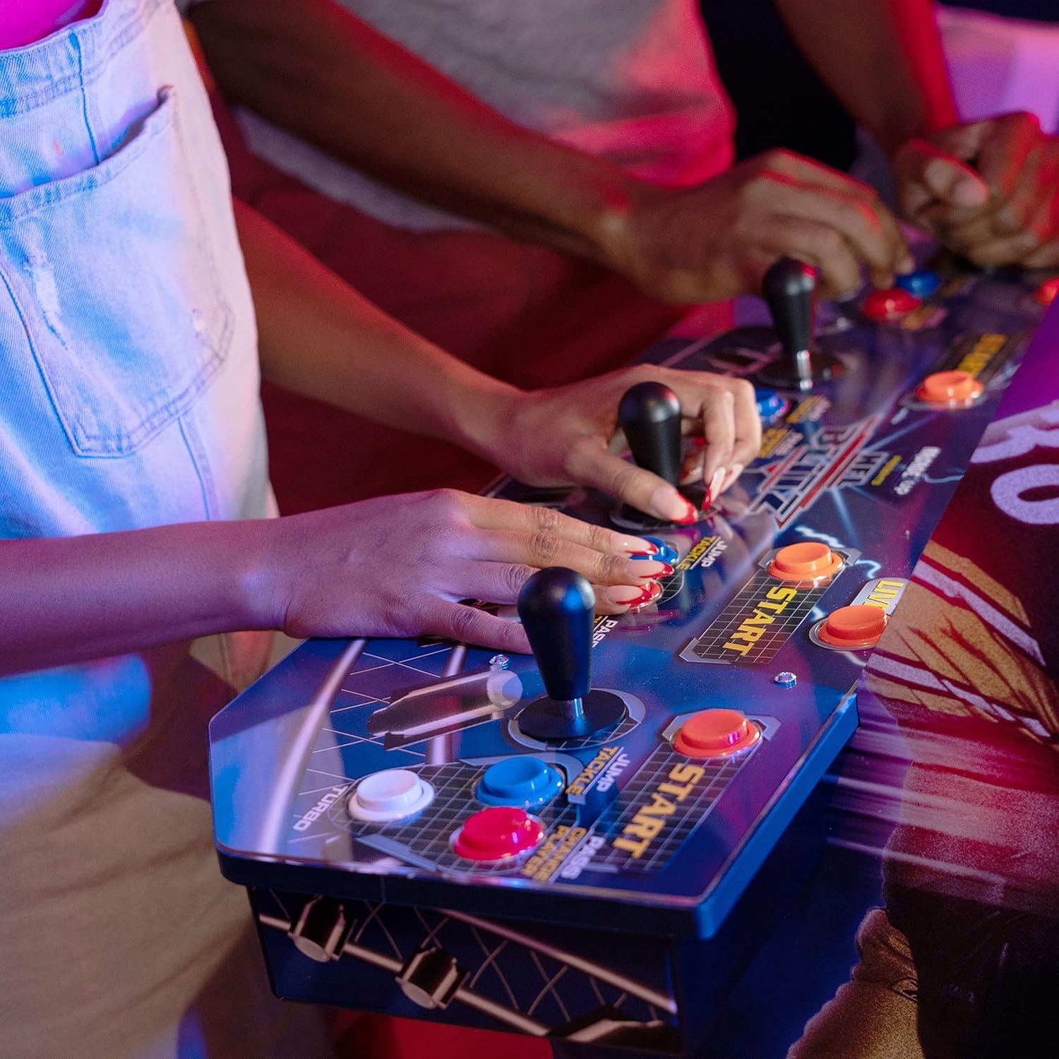 Personas jugando en una máquina arcade con joysticks y botones clásicos, panel de control retro multijugador en acción durante una partida recreativa