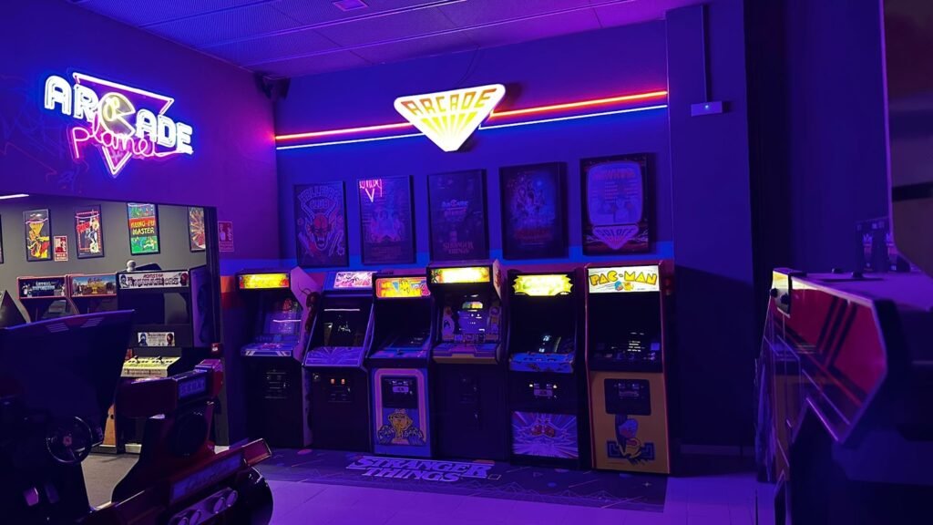 Interior de Arcade Planet Sevilla con máquinas arcade originales y rótulo luminoso