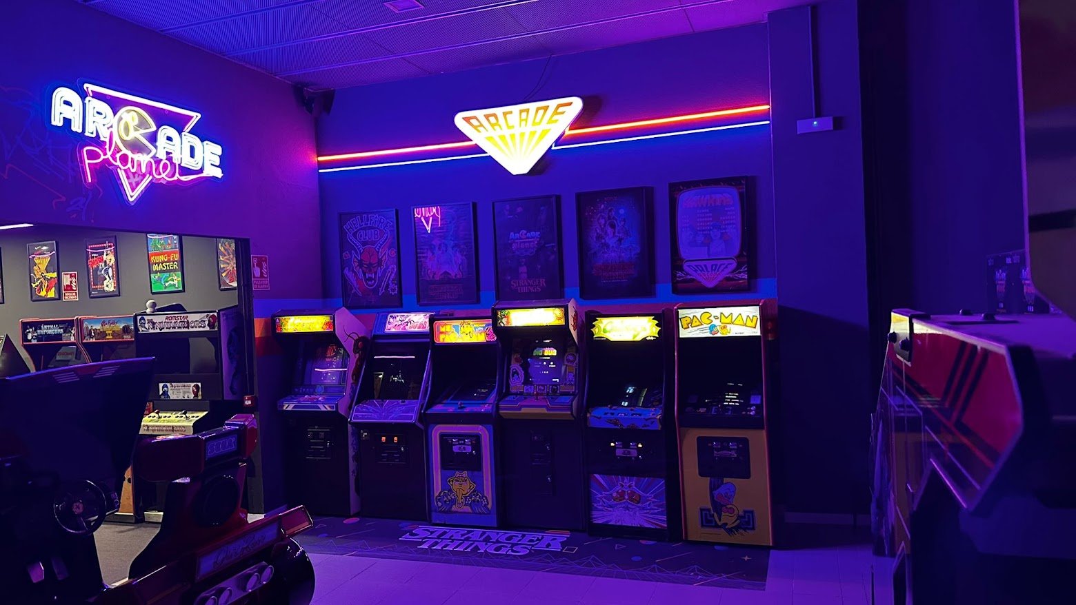 Interior de Arcade Planet Sevilla con máquinas arcade originales y rótulo luminoso